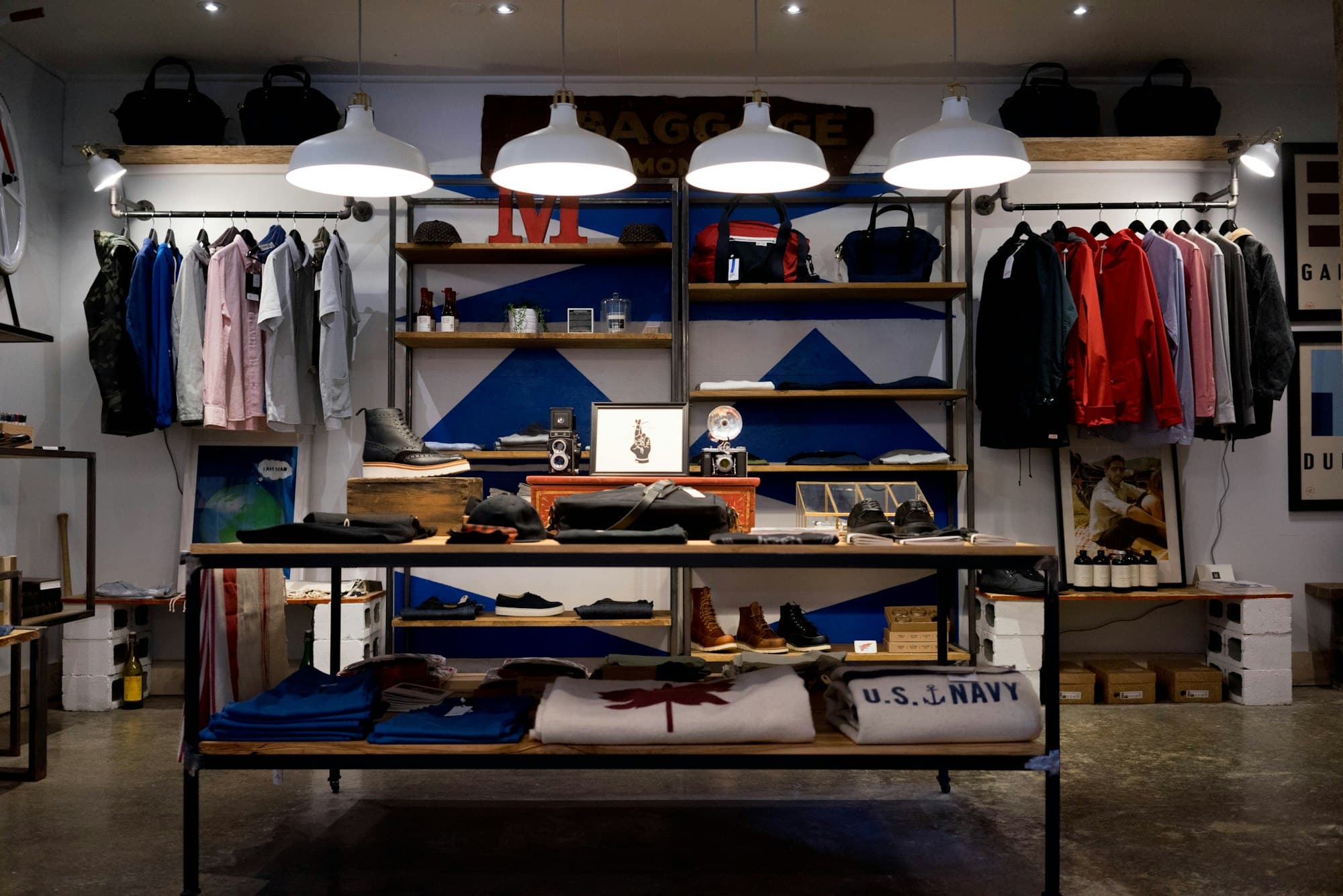 Sunlit interior of a local shop with clothing and a wooden counter